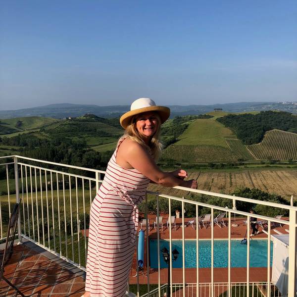 Traveler exploring a scenic vineyard hilltop in Chianti, Tuscany, Italy with rolling hills and cypress trees